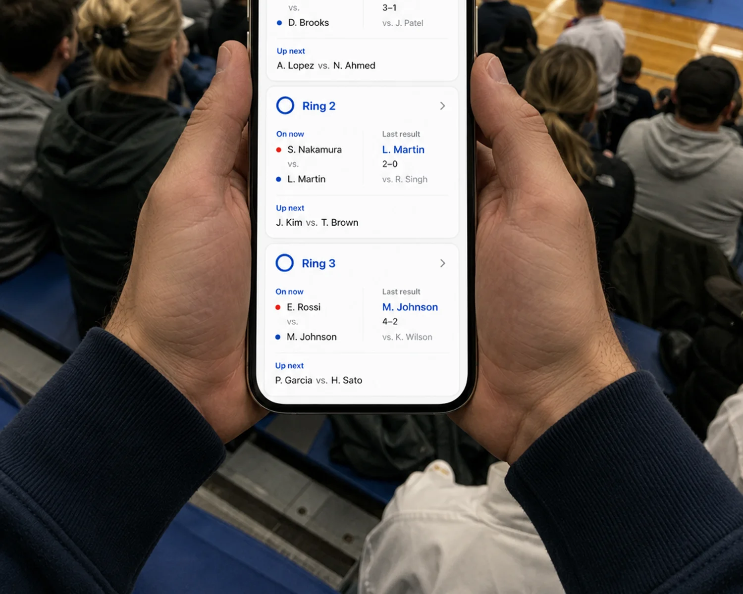 Phone showing the live spectator view with current match, last result, and up-next per ring